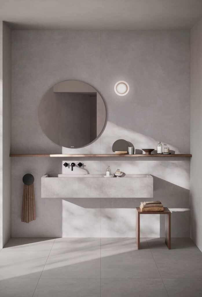 Badezimmer mit einer grauen Fliese verfliest, Waschbecken aus Feinsteinzeug. 