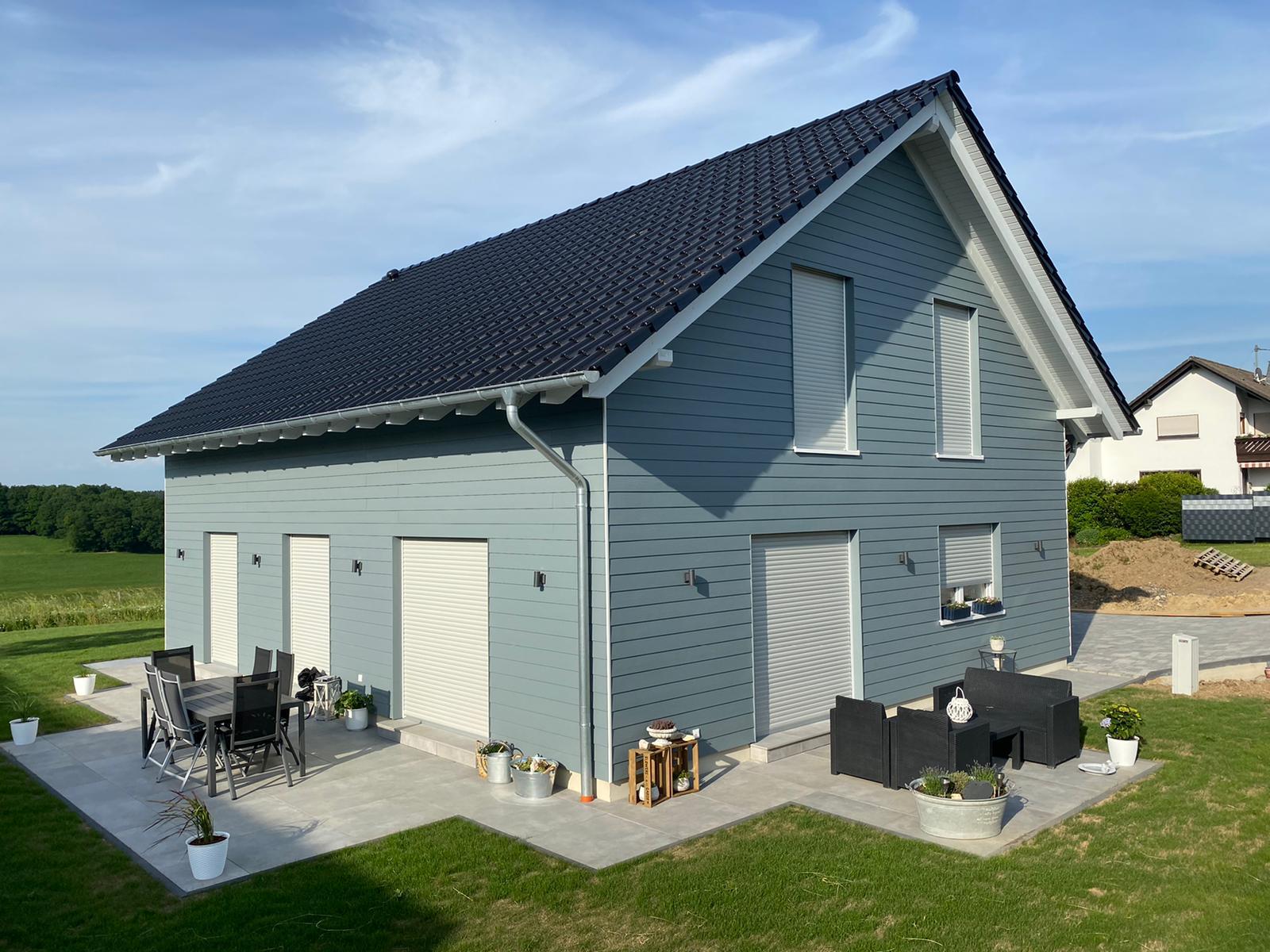 Ein freistehendes Haus mit ringsherum gefliester Terrasse