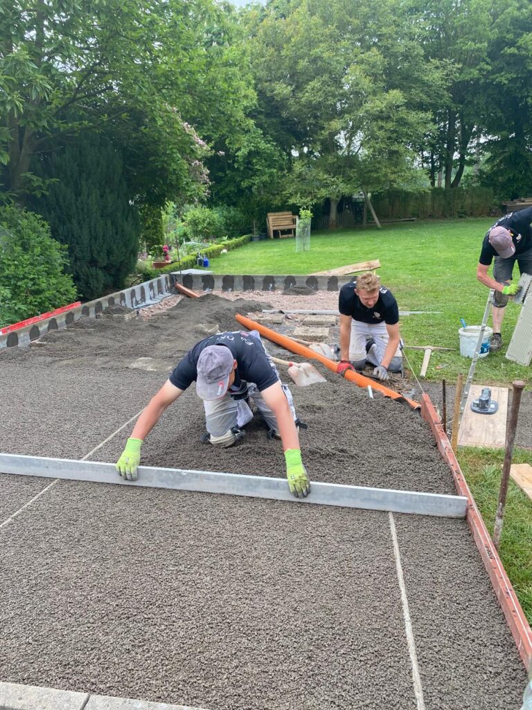 Hier wird gerade von den Handwerkern ein Splittbett aufgezogen um anschließend die Terrassenplatten darauf zu verlegen