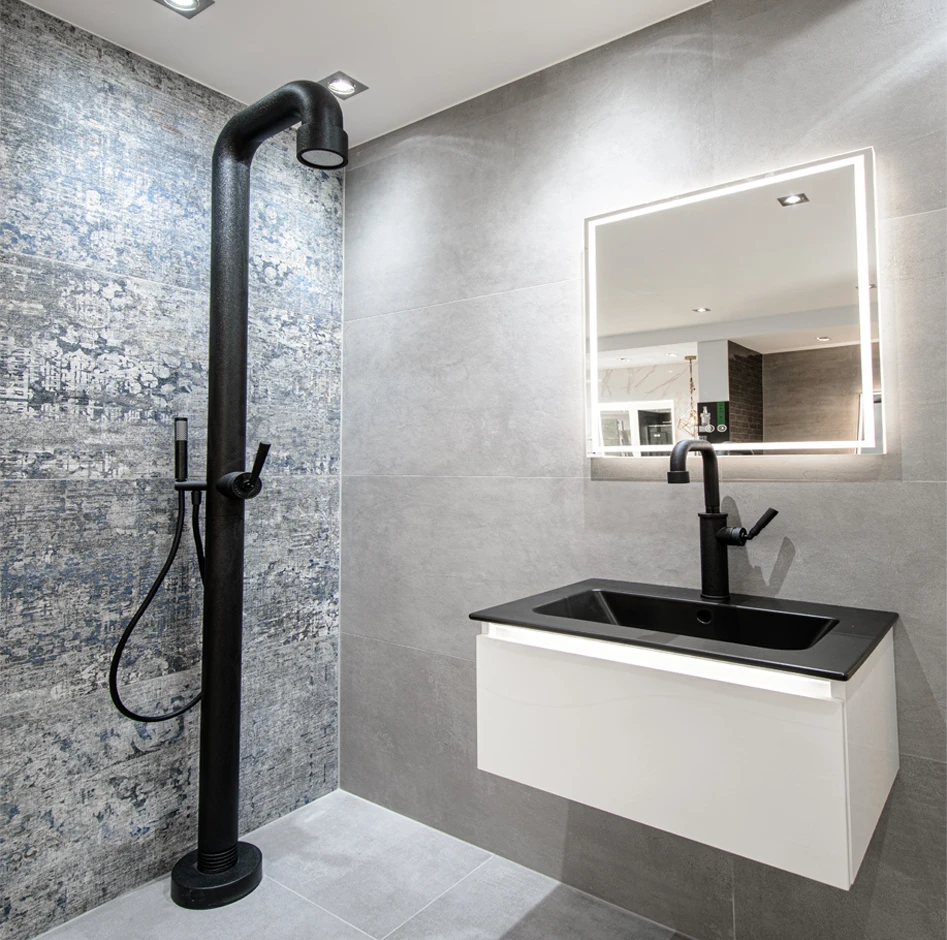 Schwarze Dusche in einem Badezimmer mit gemusterten Fliesen.