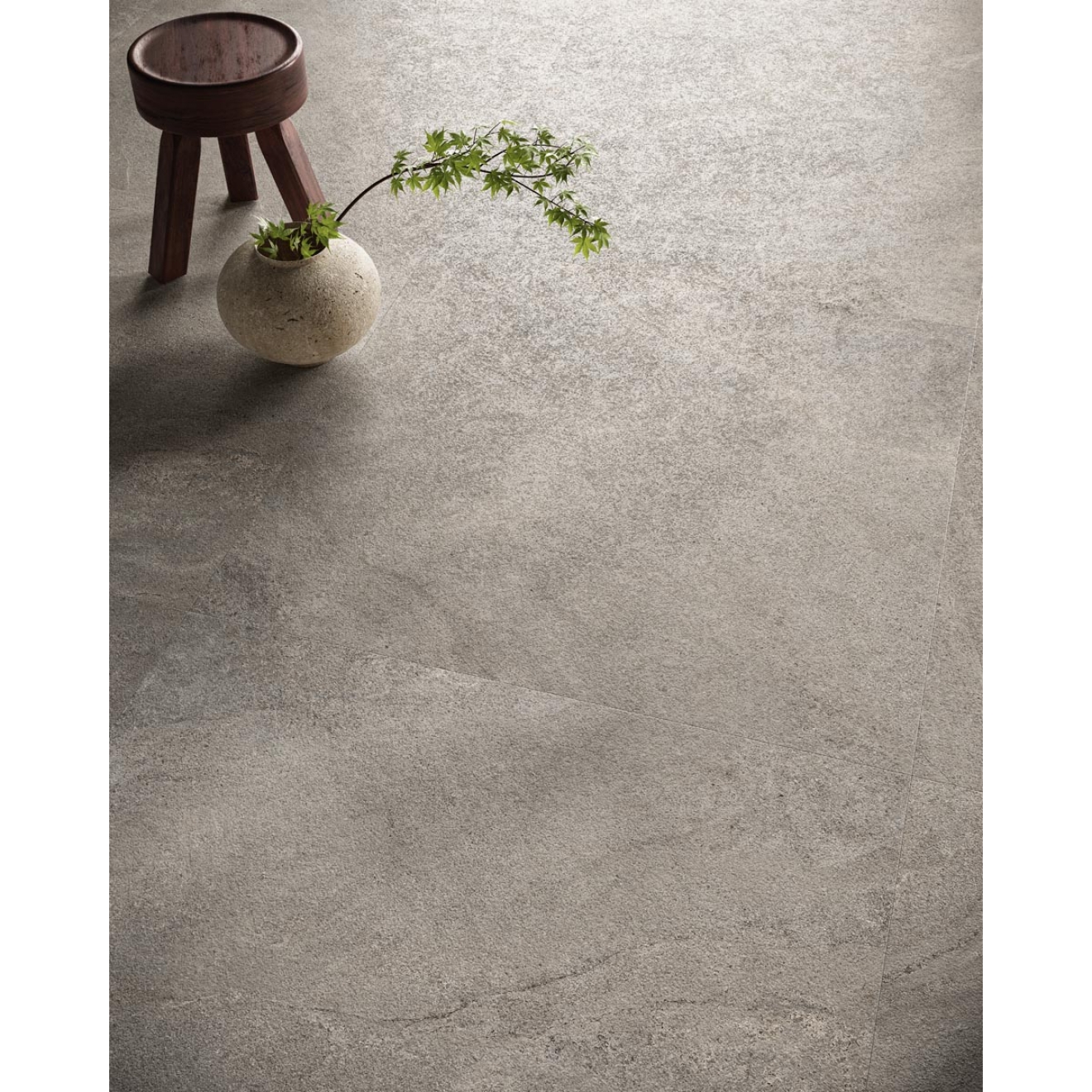 Fliese Sant Agostino Bergstone in der Farbe Grey verlegt unter einem Hocker