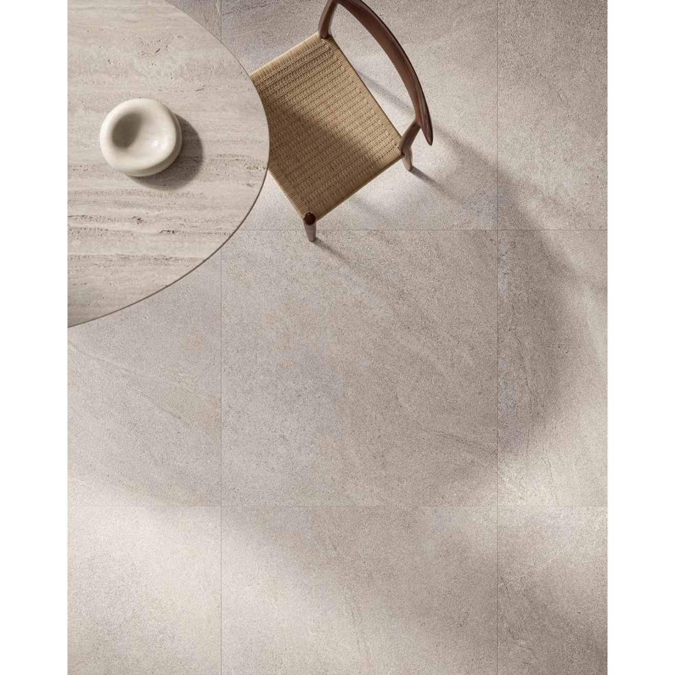 Fliese Sant Agostino Bergstone in der Farbe Pearl verlegt unter einem Tisch und Stuhl