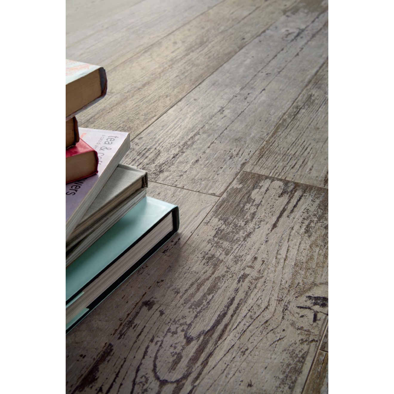 Fliese Sant Agostino Blendart in der Farbe Grey verlegt unter einem Stapel Bücher