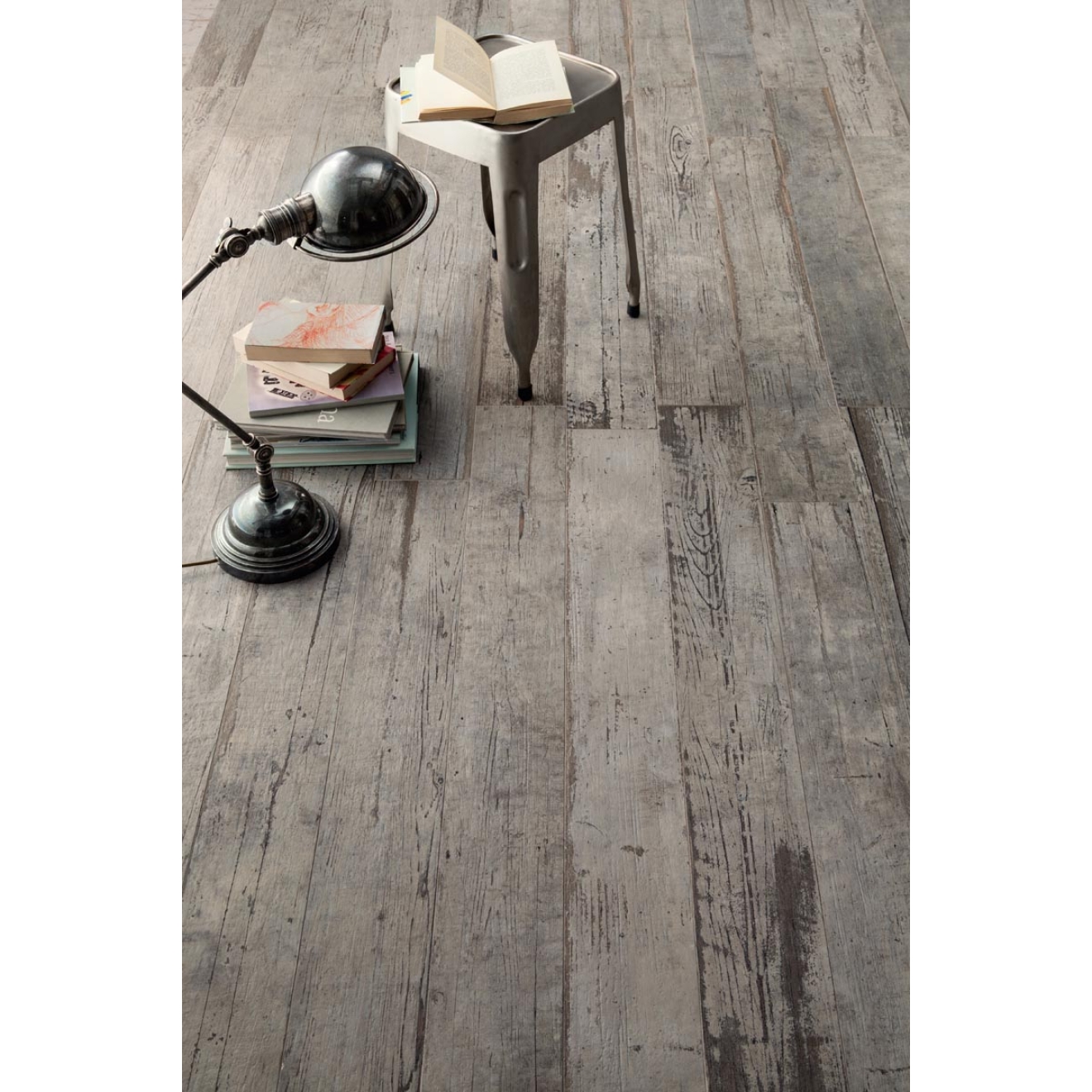 Fliese Sant Agostino Blendart in der Farbe Grey verlegt unter einem Stapel Bücher und einem Hocker