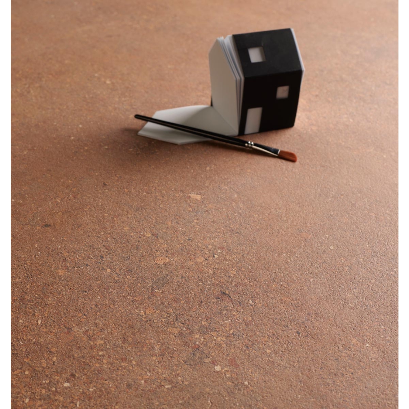 Fliese Sant Agostino Duo in der Farbe Back Cotto verlegt unter einem Notizblock und Pinsel