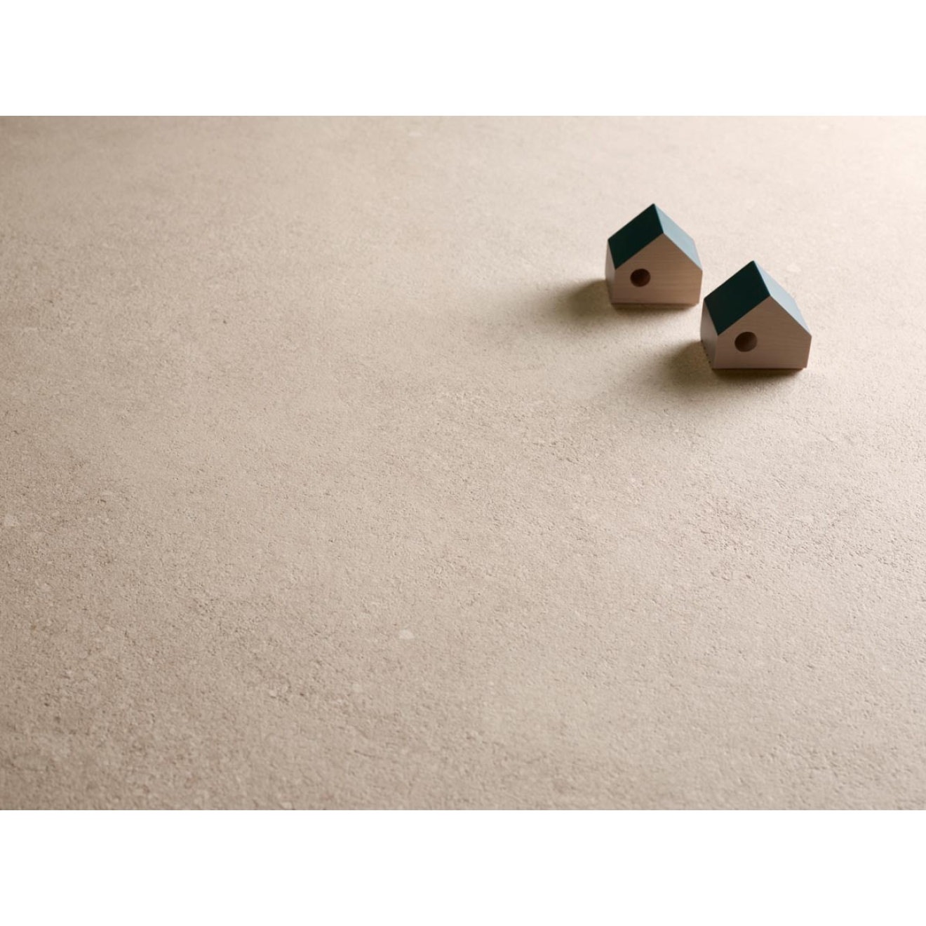 Fliese Sant Agostino Duo in der Farbe Back Desert verlegt unter zwei Miniatur Holzhäusern