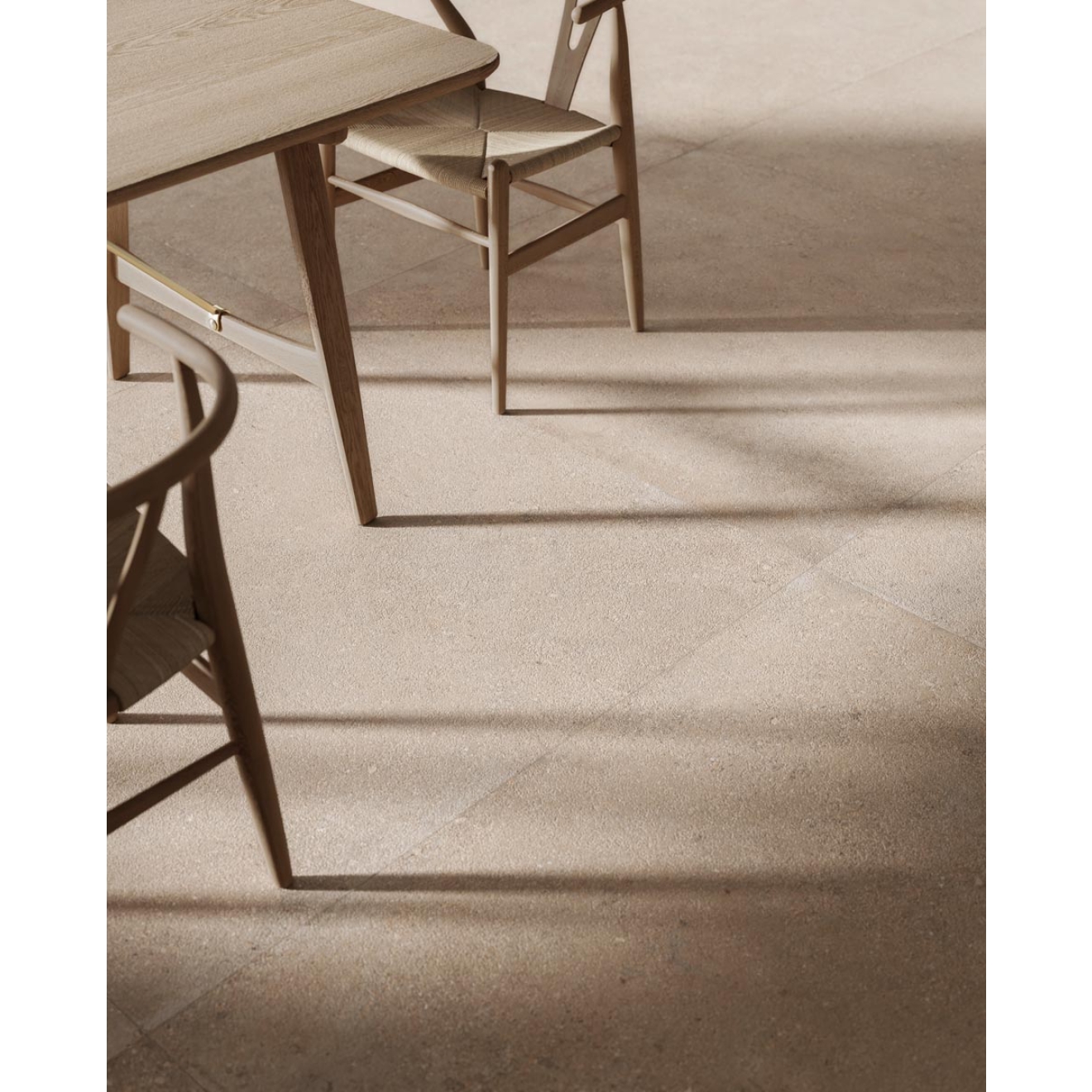 Fliese Sant Agostino Duo in der Farbe Back Sand verlegt unter einem Holztisch