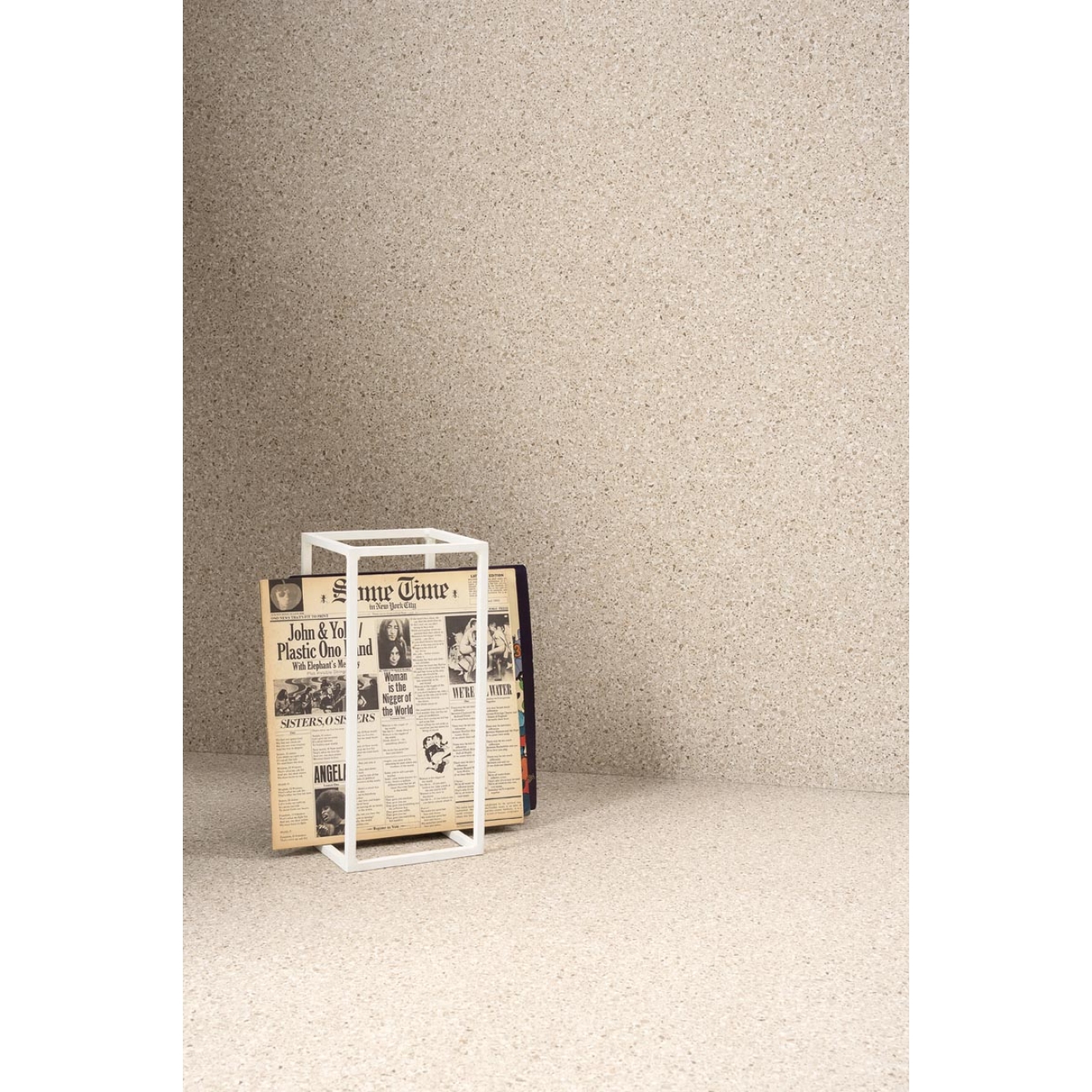 Fliese Sant Agostino Newdeco in der Farbe Sand verlegt hinter einem Quader mit einer Zeitung drin