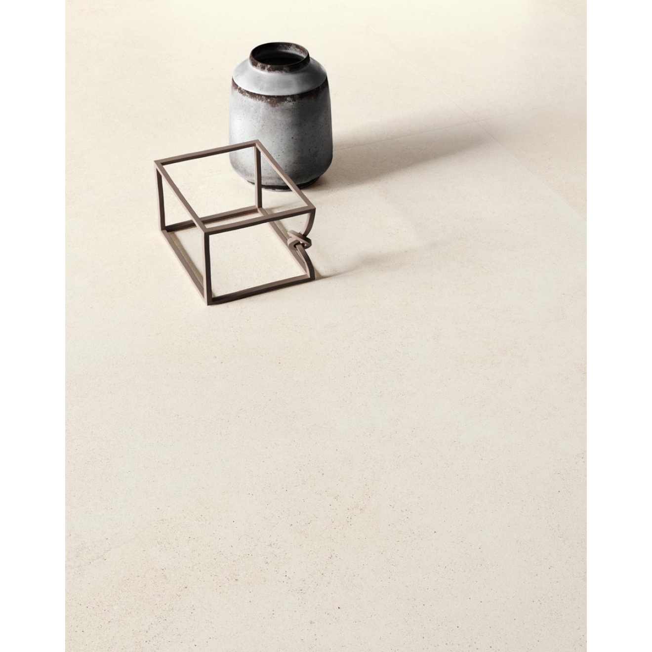 Fliese Sant Agostino Silkystone in der Farbe Light verlegt unter einem Quader und einer Vase