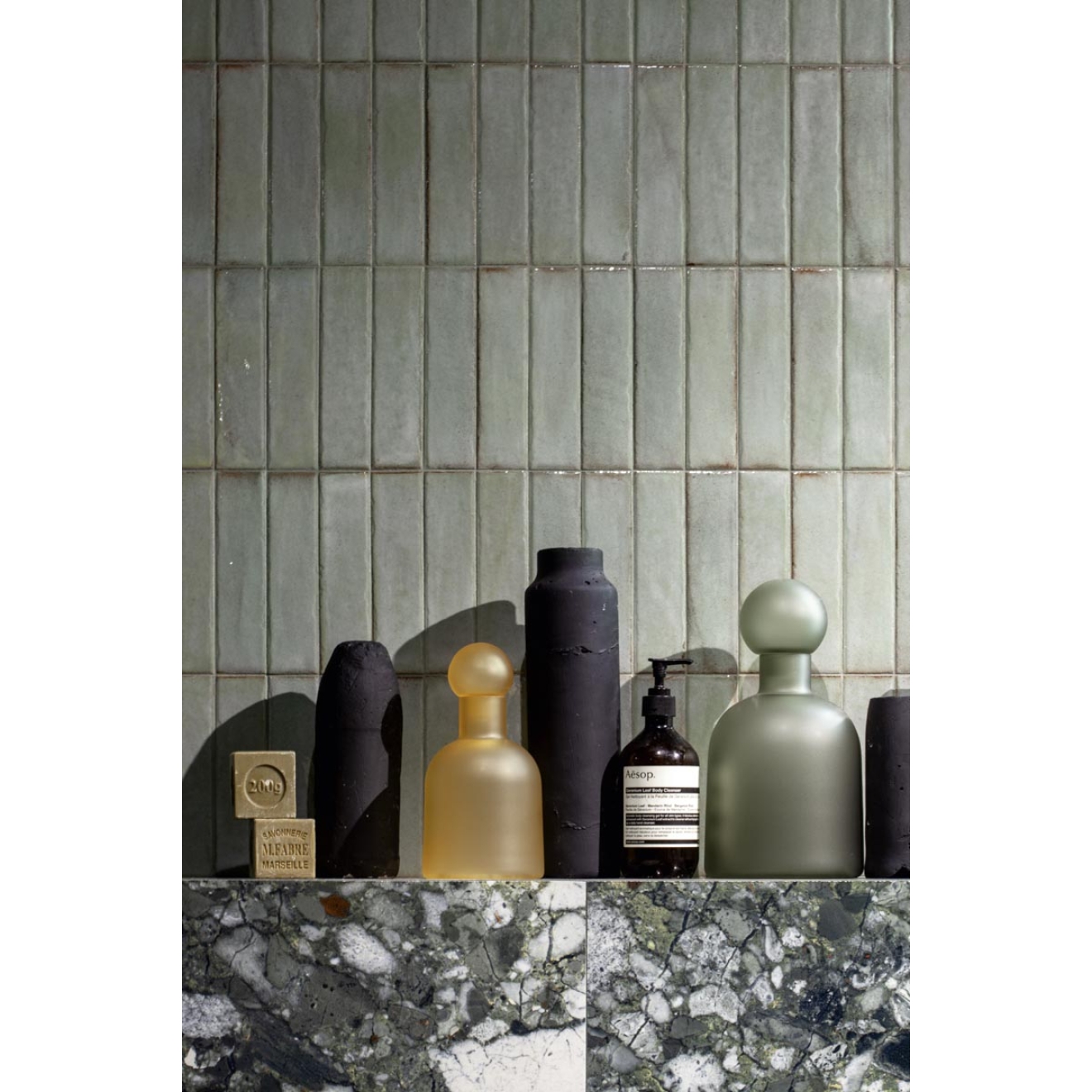 Dekor Sant Agostino Tetris in der Farbe Breeze verlegt hinter einer Reihe von Hygieneartikeln