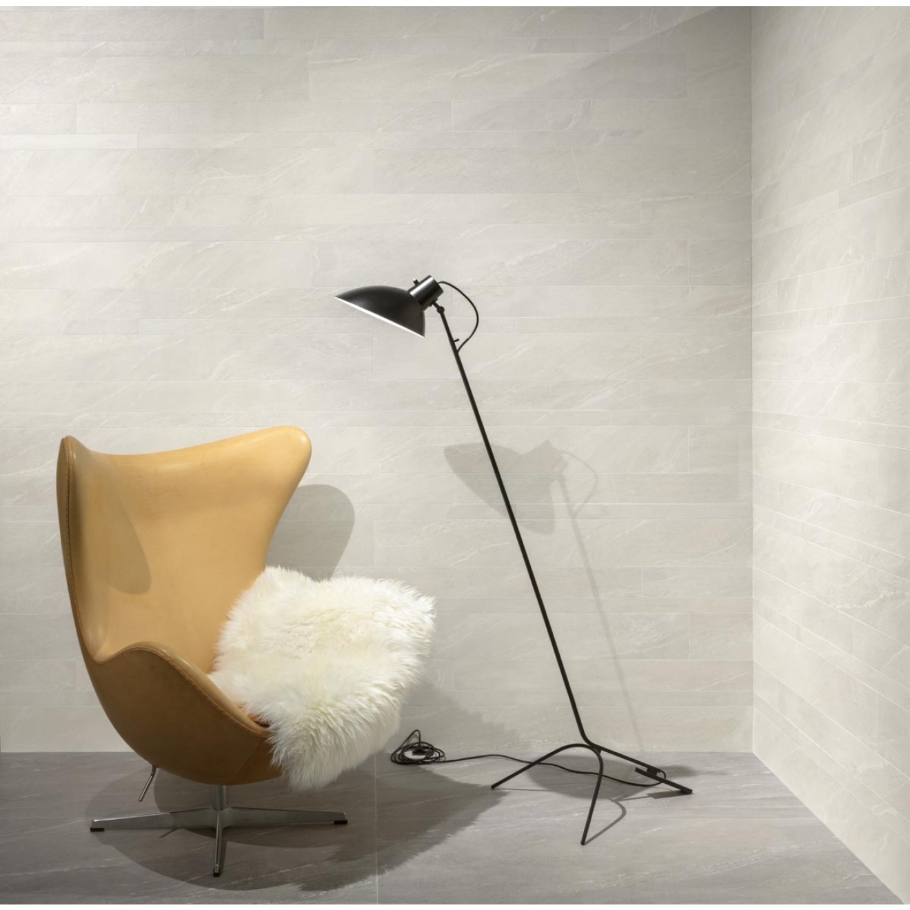 Fliese Sant Agostino Waystone in der Farbe Pearl verlegt hinter einem Sessel