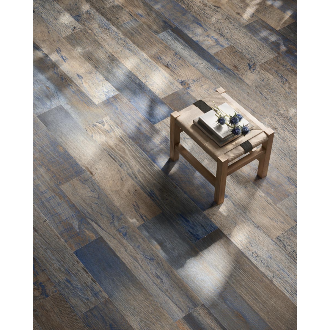 Fliese Sant Agostino Yorkwood in der Farbe Navy verlegt unter einem Hocker