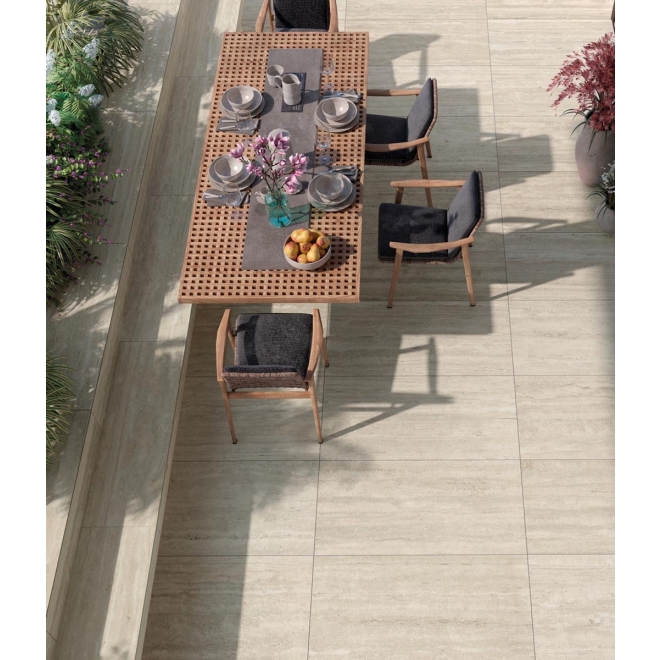 Terrassenplatte Mirage Elysian Travertini in der Farbe Light verlegt unter einem Esstisch