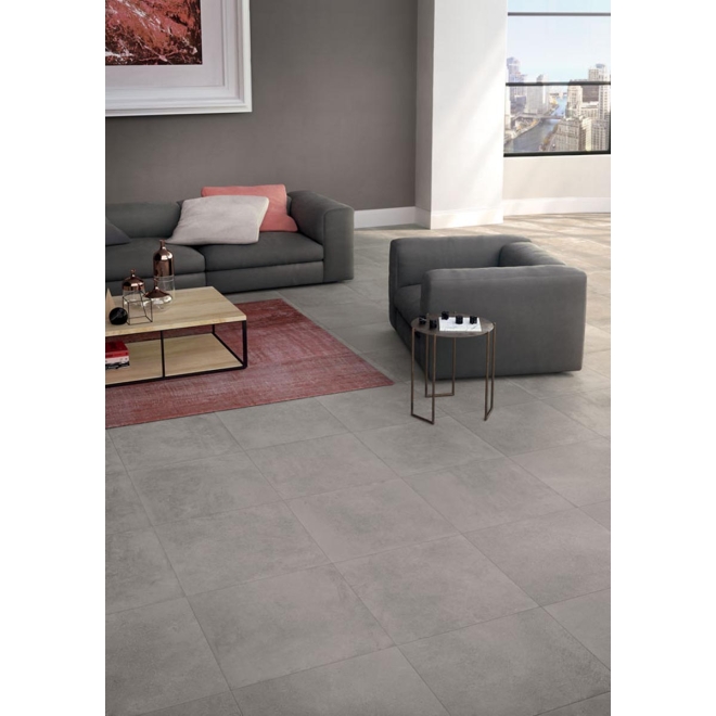 Fliese Keope Moov in der Farbe Grey verlegt unter einem Sofa und einem Sessel