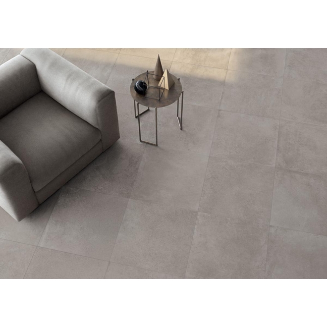Fliese Keope Moov in der Farbe Grey verlegt unter einem Sessel