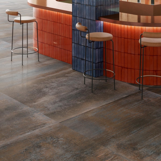 Fliese Sant Agostino Dripart in der Farbe Iron verlegt vor einer Theke