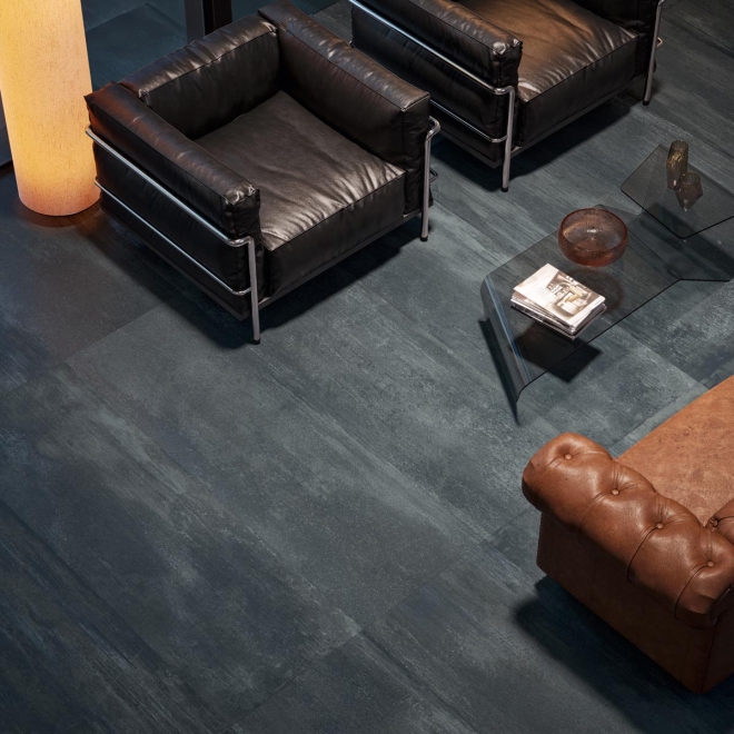 Fliese Sant Agostino Dripart in der Farbe Verdigris verlegt unter zwei Sesseln und einem Sofa