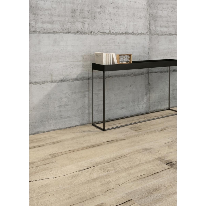 Fliese Sant Agostino Form in der Farbe Cement verlegt hinter einer Kommode mit Büchern