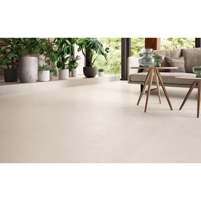 Fliese Sant Agostino Highstone in der Farbe Light verlegt unter einem Sofa und zwei Holztischen