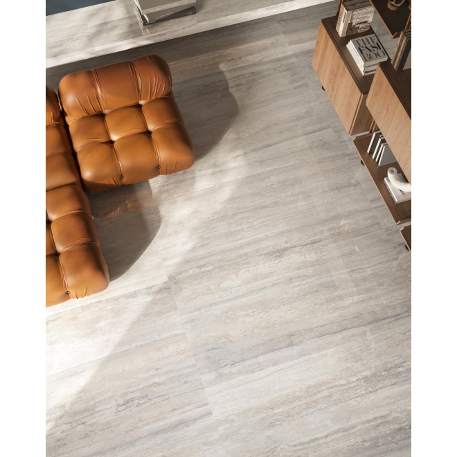 Fliese Sant Agostino Invictus in der Farbe Pearl verlegt unter einem Sofa und einem Holzregal