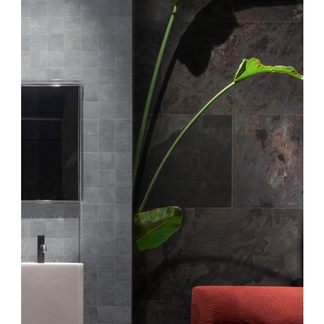 Fliese Sant Agostino Metastone in der Farbe Night verlegt hinter einer Pflanze