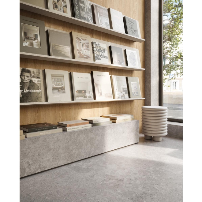 Fliese Sant Agostino Unionstone 2 in der Farbe Cedre Grey verlegt vor einem Bücherregal