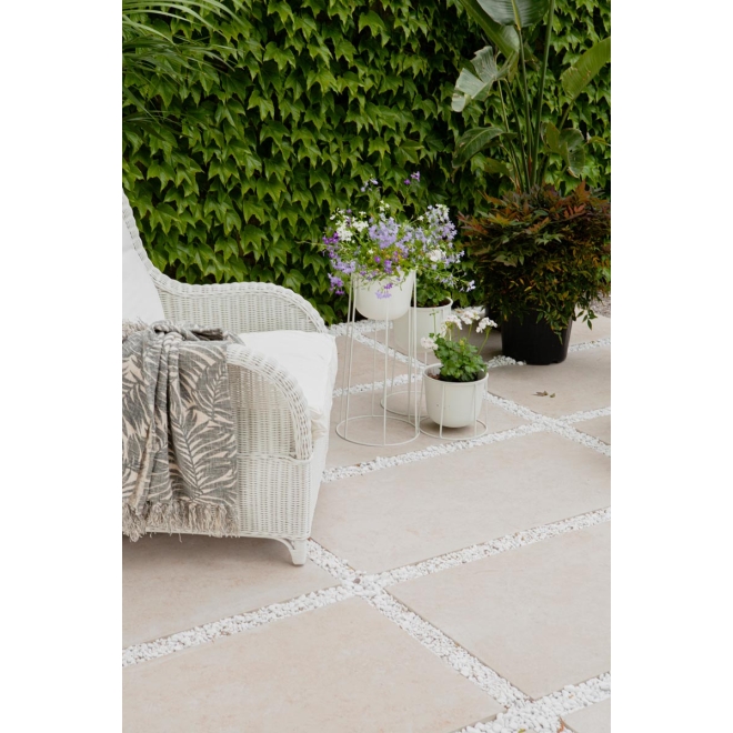 Terrassenplatte Sant Agostino Unionstone in der Farbe Jura Stone verlegt unter einem Gartenstuhl