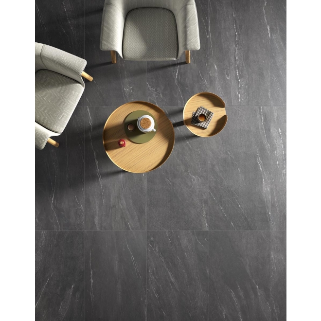 Fliese Sant Agostino Waystone in der Farbe Dark verlegt unter einem runden Tisch
