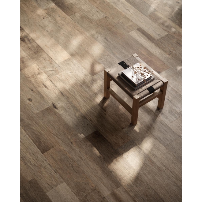 Fliese Sant Agostino Yorkwood in der Farbe Brown verlegt unter einem Hocker