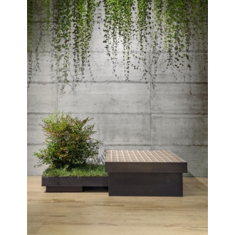 Fliese Sant Agostino Form in der Farbe Cement verlegt hinter einer Pflanze und einer Sitzmöglichkeit