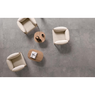 Fliese Sant Agostino Highstone in der Farbe Grey verlegt unter drei Sesseln und Holztischen
