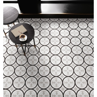 Fliese Sant Agostino Patchwork in der Farbe B&W 1 verlegt unter einem runden Holztisch eines Cafés