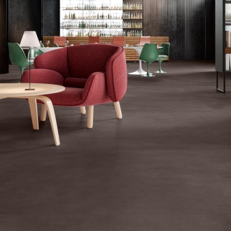 Fliese Sant Agostino Sable in der Farbe Moka verlegt unter einem Tisch und Stuhl