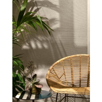 Dekor Sant Agostino Silkystone in der Farbe Sand verlegt hinter einem Korbstuhl