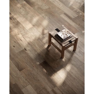 Fliese Sant Agostino Yorkwood in der Farbe Brown verlegt unter einem Hocker